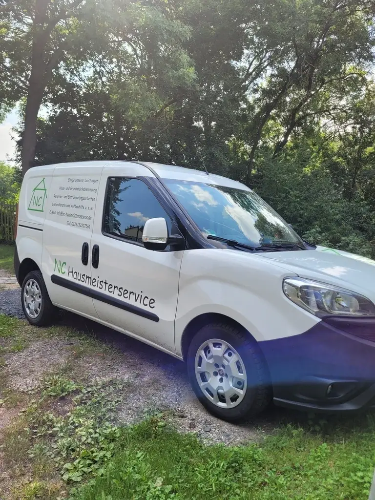 Weißer Transporter von NC-Hausmeisterservice mit grünem Logo, schräg von vorn